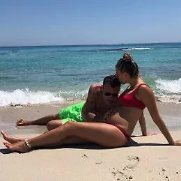 Coccole in spiaggia per il pancino di Costanza: Bobo lo accarezza