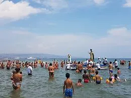 Un momento di fede tra i bagnanti alla Plaia di Catania con la processione dell'Assunta