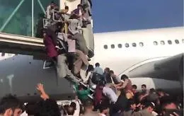 Aereo in fase di decollo inseguito sulla pista da una folla di uomini
