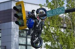 Moto appesa nel braccio del semaforo dopo un incidente: la scena surreale dopo lo schianto