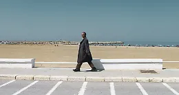 Scoglitti, l'uomo con il cappotto sul lungomare in piena estate