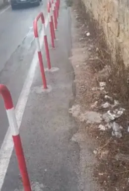 Passaggio pedonale in via Camillo Camilliani a Palermo ostacolato da transenne, erbacce e rifiuti