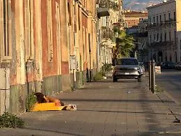 Giaciglio di fortuna per una donna in via Domenico Tempio: scene di degrado urbano e sociale a Catania