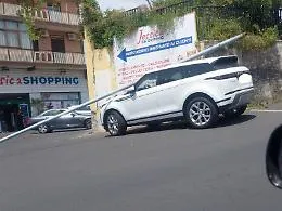 Palo della luce cade su un'auto in sosta: tetto schiacciato e parabrezza in frantumi