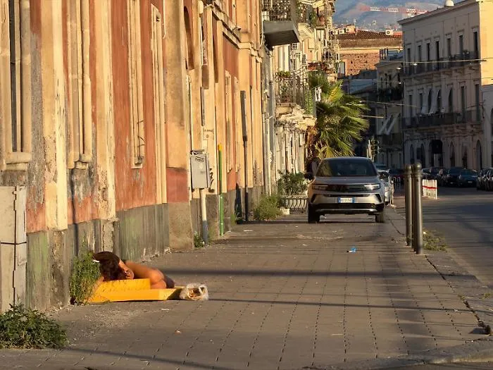 Giaciglio di fortuna per una donna in via Domenico Tempio: scene di degrado urbano e sociale a Catania